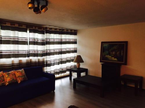 uma sala de estar com um sofá e uma janela em CDMX - Great Location at Napoles em Cidade do México