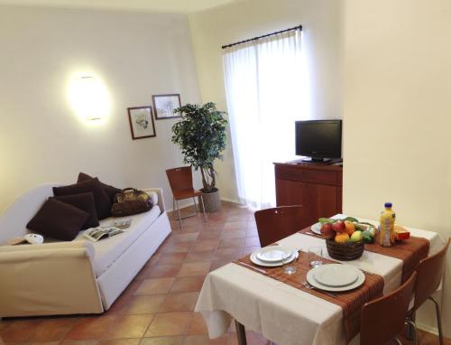 ein Wohnzimmer mit einem Tisch und einem Sofa in der Unterkunft Residence Villa Firenze in Alassio