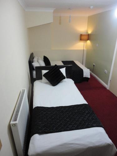 una camera con tre letti in bianco e nero di City View Hotel - Roman Road Market a Londra