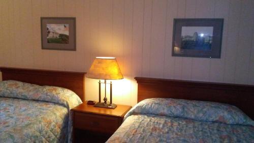 a hotel room with two beds and a lamp on a table at Catskill Motor Court in Catskill