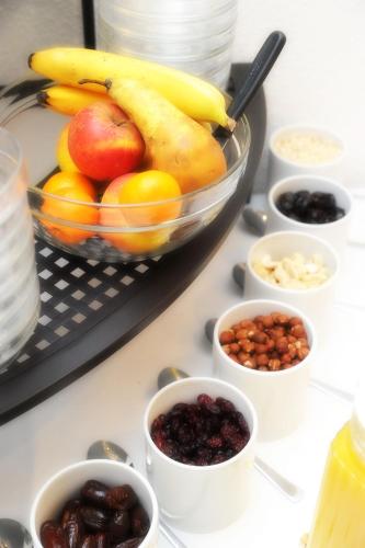 a table topped with bowls of fruit and nuts at Hotel Waldesruh in Düsseldorf