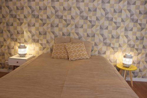 a bedroom with a bed with two lamps on it at Casa da Azarujinha in Estoril