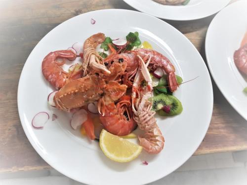 a plate of shrimp and vegetables on a table at Hotel Ambra in Forte dei Marmi
