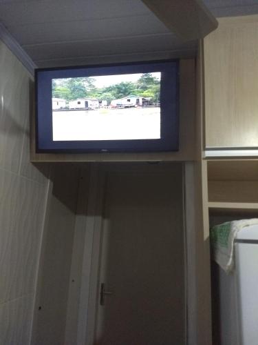 a flat screen tv on a wall in a room at Edícula aconchegante 100m do Mar in Sombrio
