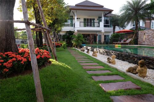 un jardín con algunos osos de juguete sentados en la hierba en Starry Night Villa by Zhang Bin, en Chiang Mai