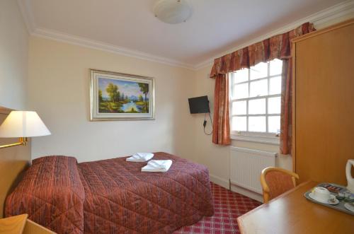 a hotel room with a bed and a window at Seymour Hotel in London