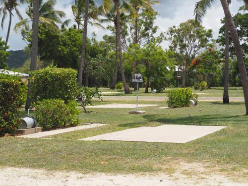 a park with palm trees and a basketball hoop at Bowen Holiday Park in Bowen