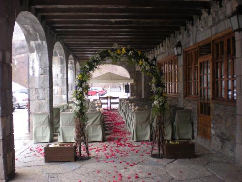 um corredor com cadeiras e um arco com flores em Parador de Bielsa em Espierba