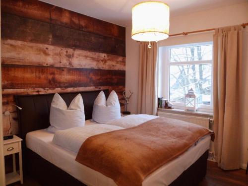 ein Schlafzimmer mit einem großen Bett und einer Holzwand in der Unterkunft Harzglück in Hahnenklee-Bockswiese