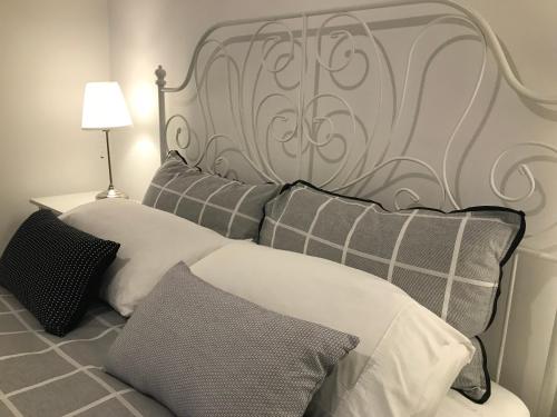 a bedroom with a bed with a headboard and pillows at Whitening Cottage in Tumbarumba