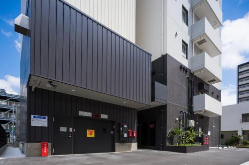 a black and white building in a city at Tissage Hotel Naha by Nest in Naha