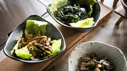 three bowls of food on a wooden table at Tissage Hotel Naha by Nest in Naha