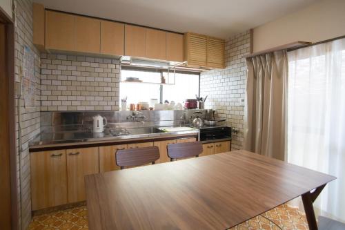 松山的住宿－道後宿度假屋，厨房配有木桌和水槽。