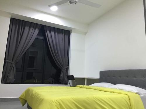 a bedroom with a yellow bed and a window at Mayzi Holiday Home @ Cyberjaya in Cyberjaya
