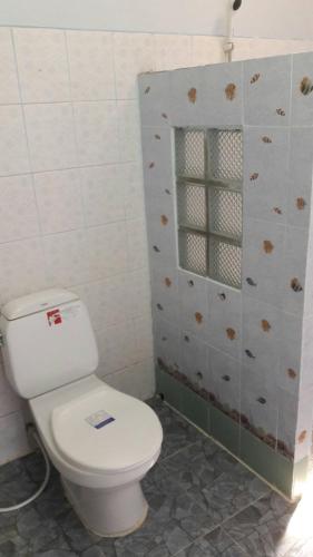 a bathroom with a white toilet and a window at Diamond Sand Palace - SHA Plus in Ko Lanta