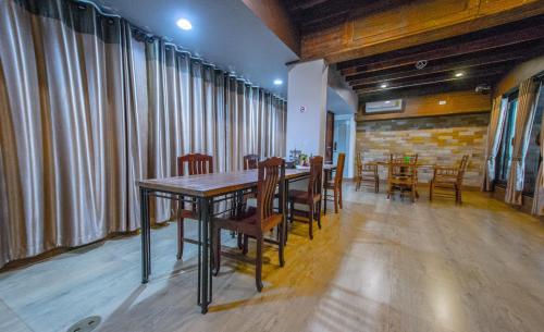 a dining room with a wooden table and chairs at Na Siri Lake View in Samut Prakan