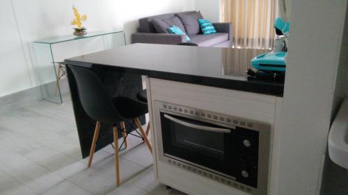 a living room with a kitchen with a counter top at O local para o seu lazer in Santos