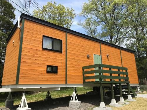 a tiny house on display with a bench at DogrunCafe & Resorts JENNIE West-Karuizawa in Miyota
