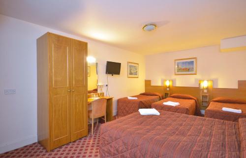 a hotel room with two beds and a desk at Seymour Hotel in London
