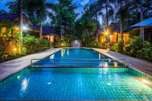 a swimming pool in front of a house at night at Sunda Resort in Ao Nang Beach
