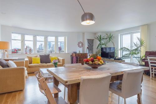 a living room with a table with a bowl of fruit on it at Spectacular River Thames View in London