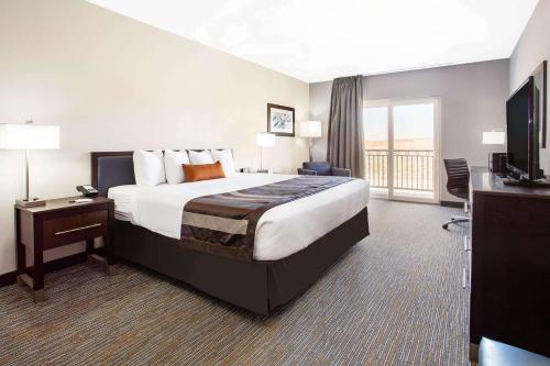 ページにあるウインゲート バイ ウィンダム ページ レイク パウエルの大型ベッドとテレビが備わるホテルルームです。