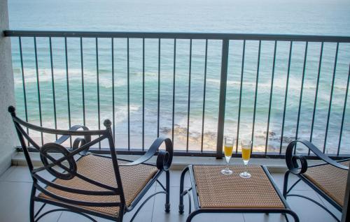 two chairs and a table on a balcony with the ocean at 1104 The Bermudas - by Stay in Umhlanga in Durban