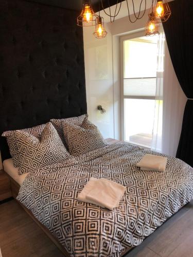 a bedroom with a large bed with two towels on it at Family Apartment Golden Tulip in Międzyzdroje