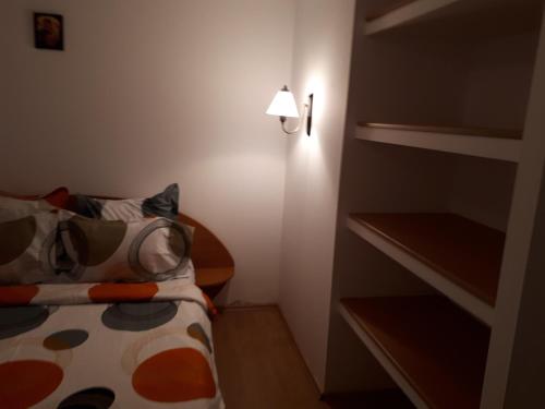 a small room with a bed and a lamp at Cabana Beea in Dubova