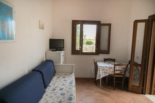 a living room with a blue couch and a table at Case Canino in Favignana