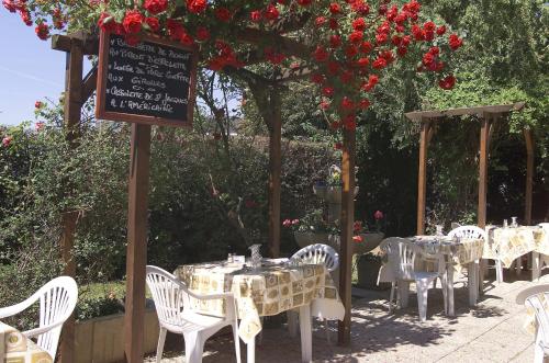 a restaurant with tables and chairs and a sign with flowers at Logis Hôtel - Le Relais du Parisis in Villeparisis