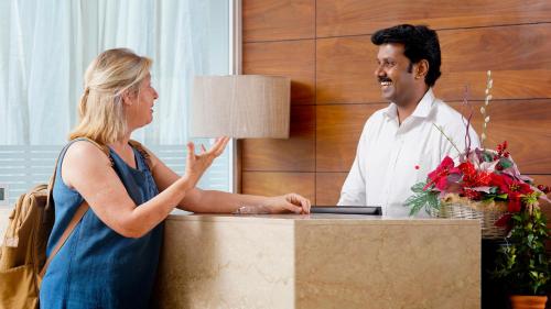 a man and a woman standing in front of a desk at Niko Hotels in Cochin