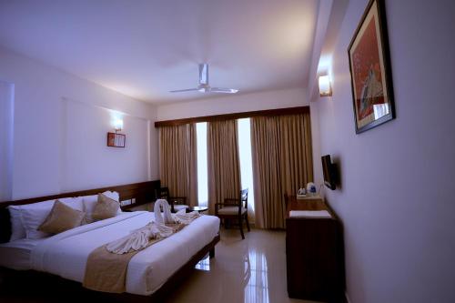 a hotel room with two beds and a window at Niko Hotels in Cochin