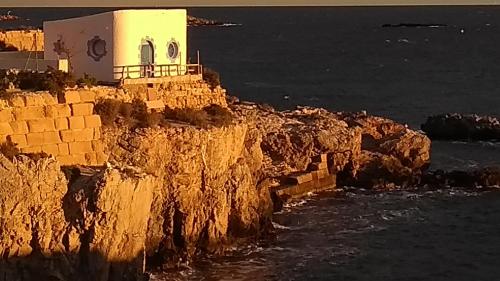 a building on a cliff next to the ocean at Calatabarca B&B in Tabarca