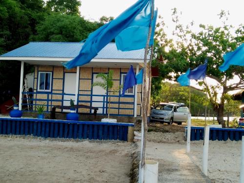 a house with blue flags in front of it at Bolo Beach Santorini nearby to Hundred Island in Alaminos