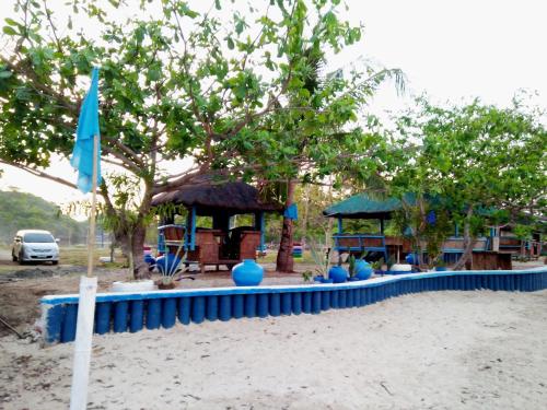 a playground on the beach with a blue umbrella at Bolo Beach Santorini nearby to Hundred Island in Alaminos