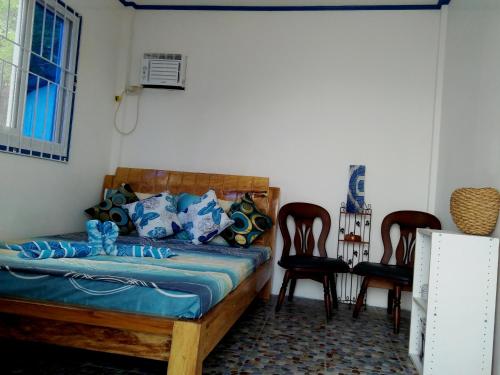 a bedroom with a bed and two chairs at Bolo Beach Santorini nearby to Hundred Island in Alaminos