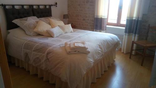 a bedroom with a bed with two towels on it at Les Gîtes du Breuillat in Paillé