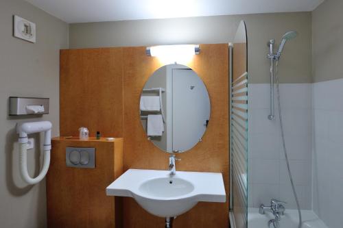 a bathroom with a sink and a mirror at Hôtel du Parc Nantes Ouest Orvault in Orvault