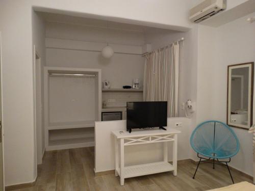 a living room with a television and a chair at Naxos Lane Center Studios in Naxos Chora