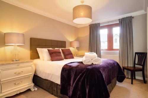 ALTIDO Elegant 2 bed, 2 bath flat, patio and free parking في إدنبرة: غرفة نوم مع سرير وفوط على طاولة