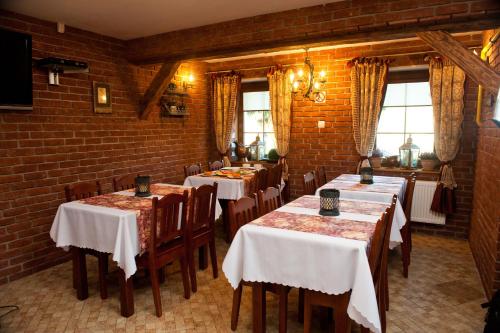 a dining room with tables and chairs and a brick wall at Willa Ostoja in Świeradów-Zdrój