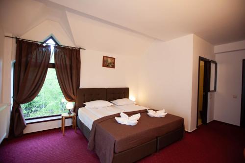 a bedroom with a bed with two white flowers on it at Casa Vlasin in Poiana Brasov