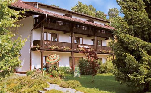 une grande maison avec un jardin en face de celle-ci dans l'établissement Pension Berglehner, à Bad Griesbach im Rottal