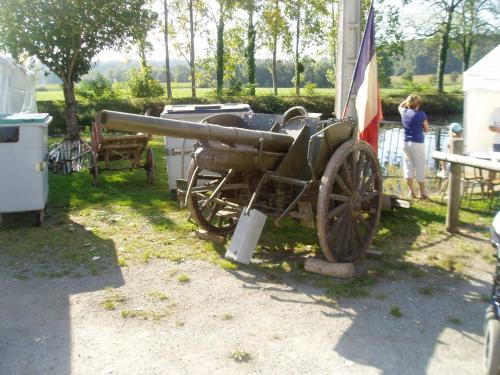 a cannon sitting next to a building with a woman at Caux-Breizh in Rohan
