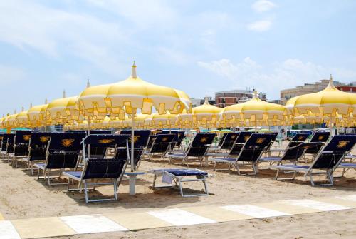 a group of chairs and umbrellas on a beach at Hotel Eureka in Rimini