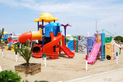 um parque infantil com um equipamento de brincar colorido na areia em Hotel Eureka em Rimini