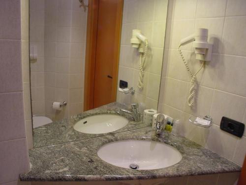 a bathroom counter with a sink and a phone at Hotel Don Abbondio in Lecco