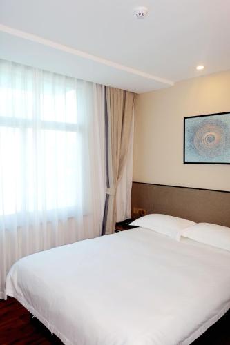 Postel nebo postele na pokoji v ubytování Hangzhou Yuqi Hotel
