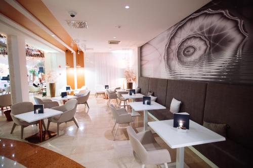 a restaurant with tables and chairs and an eye mural at Grand Hotel Portoroz 4* superior – Terme & Wellness LifeClass in Portorož